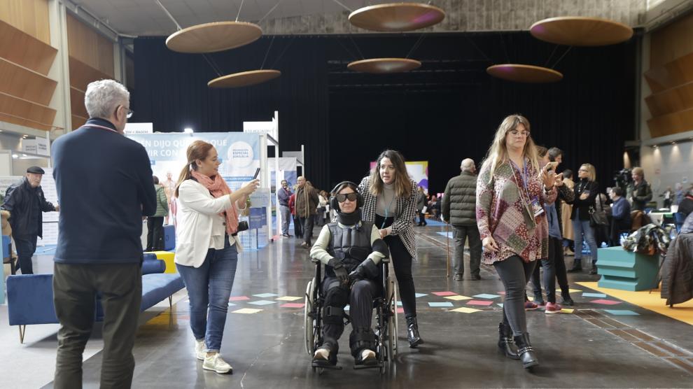 Eva Caballero va en silla de ruedas con los elementos que le permiten meterse en la piel de una persona mayor con limitaciones físicas y sensoriales