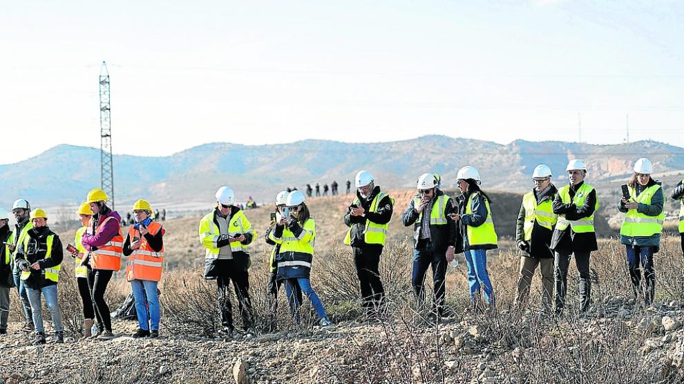 Trabajadores de Endesa presencian el derrumbamiento de la chimenea.