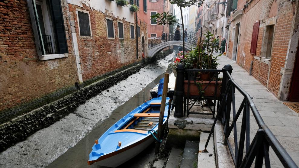 Boats are pictured in a canal during a severe low tide in the lagoon city of Venice, Italy, February 17, 202. REUTERS/Manuel Silvestri EUROPE-WEATHER/ITALY-DROUGHT