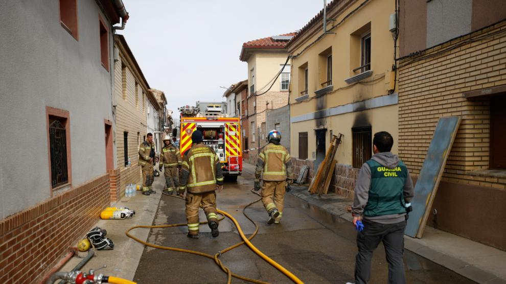 Bomberos y guardias civiles trabajan tras declararse un incendio que ha acabado con la vida de dos personas, en Cabañas de Ebro.