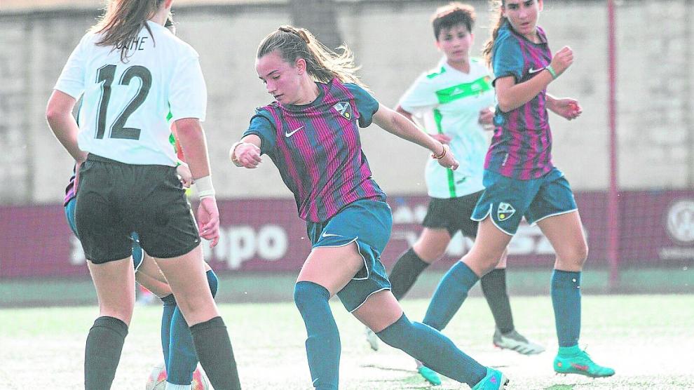 Una jugadora de la SD Huesca avanza con el balón controlado.