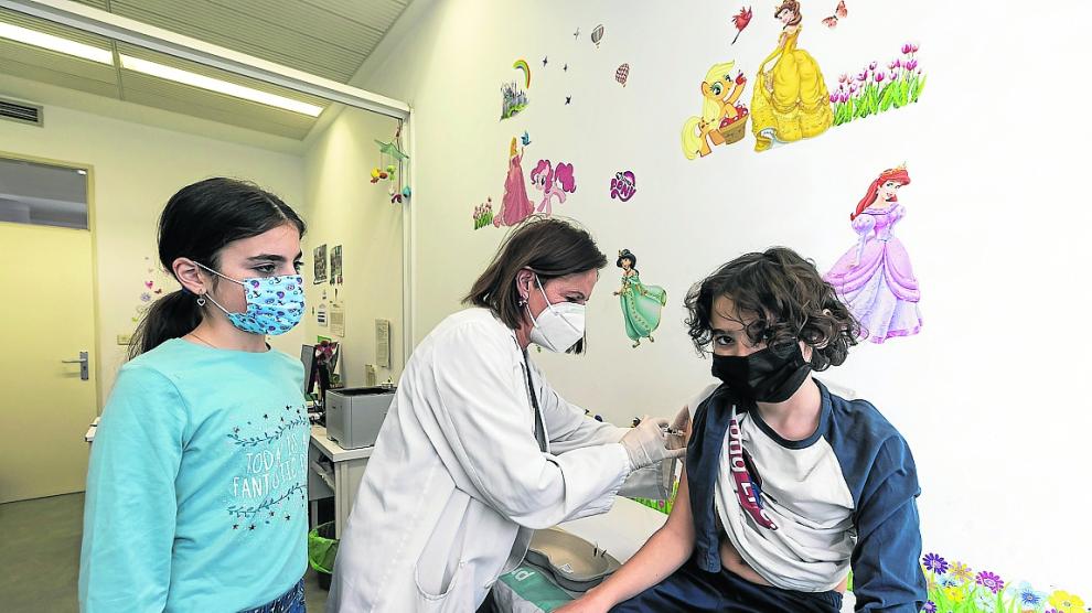 La enfermera Teresa Tolosana vacuna contra papiloma a Abel, junto a su hermana melliza, Ainhoa.