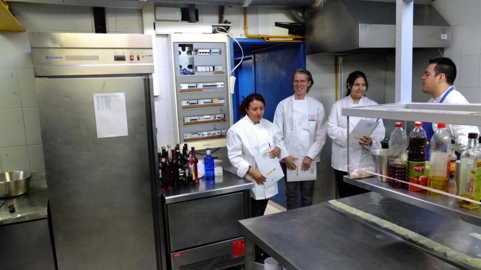Noemí Oliver, Karla Carpio y Yevgen Shapovalov, en las cocinas del Lillas Pastia con Gabriel, uno de los cocineros.