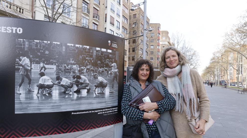 Nines Gracia y Esther Wender posan este martes en Gran Vía, en la exposición 'Zaragoza, ciudad de baloncesto', junto a una fotografía suya de hace 30 años.