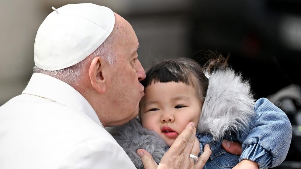 El Papa Francisco besa a un niño al final de su audiencia general semanal en la Plaza de San Pedro.
