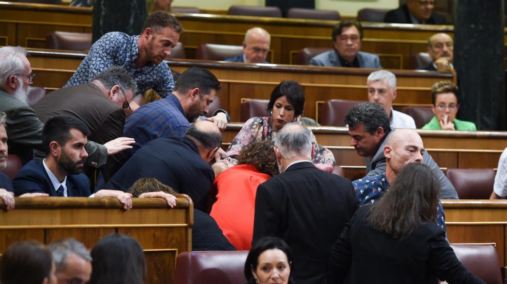 Varias personas atienden a la diputada de Unidas Podemos Marisa Saavedra tras sufrir un desvanecimiento.