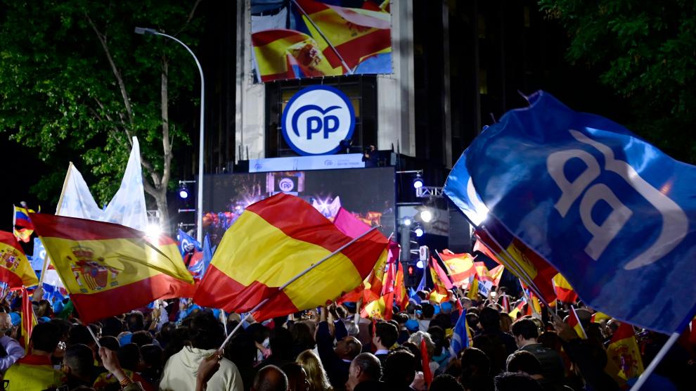 Cientos de militantes del PP celebran el resultado electoral delante de la sede nacional del partido, en la calle Génova de Madrid.