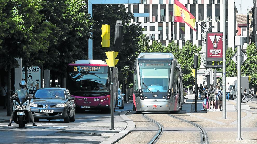 Un autobús de la línea 21 y un tranvía, a su paso por la plaza de España de Zaragoza.