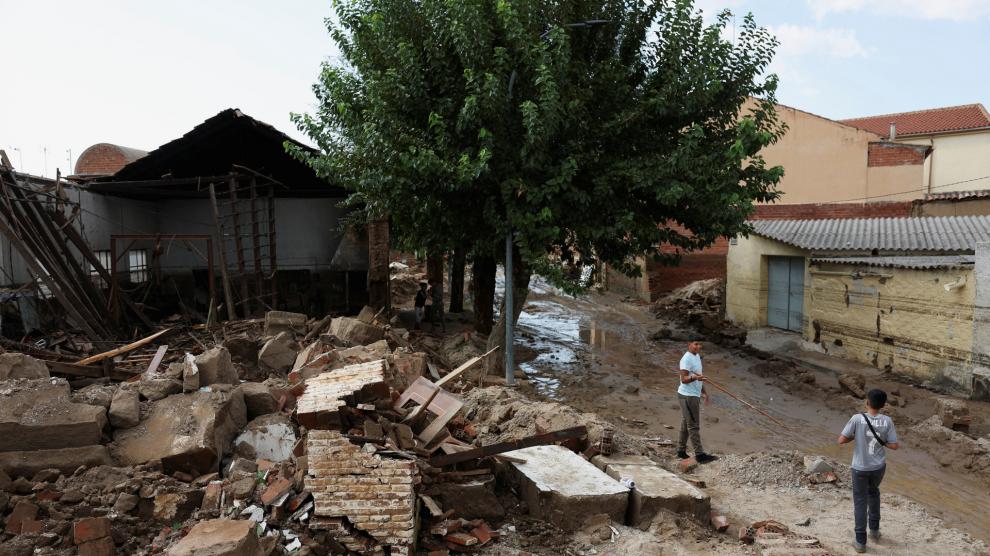 Los residentes se encuentran cerca de escombros amontonados tras inundaciones y fuertes lluvias, en Chozas de Canales, provincia de Toledo.
