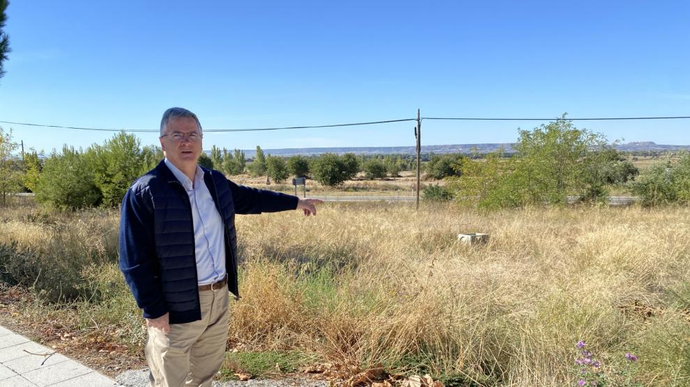 El alcalde de Castejón del Puente, Antonio Comps, junto al terreno donde se va a edificar.