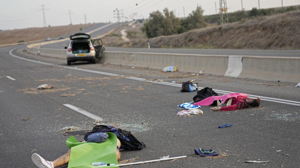 Israelis killed by Hamas militants lie on the road near Sderot, Israel, on Oct. 7, 2023. Palestinian militants from the Gaza Strip infiltrated southern Israel Saturday and fired thousands of rockets into the country, prompting Israel to begin striking targets in Gaza in response. (AP Photo/Ohad Zwigenberg)