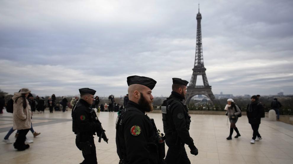 Gendarmes armados patrullan por Trocadero, cerca de la torre Eiffel, este domingo en París.