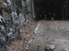 Las piedras que cayeron a la carretera cerca de la presa de Plandescún.