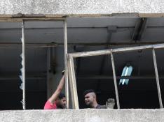 Dos hombres trabajan para reparar uno de los edificios afectados por la explosión este jueves en Beirut.