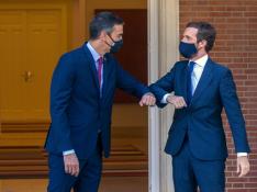 Pedro Sánchez y Pablo Casado se saludan con el codo antes de la reunión de este miércoles.