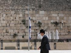 Un judío ultraortodoxo pasa delante de una bandera a media asta en Jerusalén
