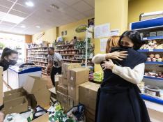Svitlana Berlus abraza a Natalia Liudmyla, en presencia de  Yuri Isayev, en la tienda Kozak, donde se recoge  material para Ucrania, en Zaragoza