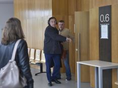 El guardia civil acusado de abusos, con chaqueta marrón, saliendo de la sala de vistas de la Audiencia de Huesca con su abogado.