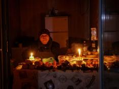 Una mujer atiende con velas en su establecimiento en una Odesa a oscuras.