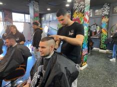 Los alumnos de la Escuela de barbería del Tío Jorge practican con algunos clientes.