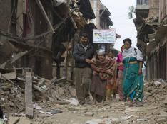 Varios nepalíes recogen algunas pertenencias de entre los escombros