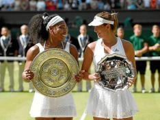 Serena Williams y Garbiñe Muguruza se sonríen en la entrega de trofeos tras la final de Wimbledon.