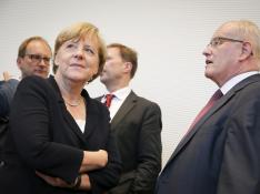 La canciller alemana, Angela Merkel, conversa con el jefe del grupo parlamentario conservador durante la reunión del lunes por la tarde.