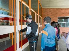 El profesor de educación física del Guillermo Fatás abre la puerta del pabellón a sus alumnos.