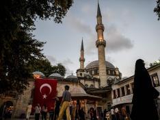 Una bandera turca ondea junto a una mezquita en Estambul.