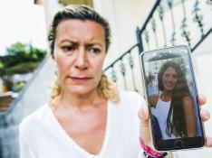 La madre de la joven desaparecida muestra su fotografía.