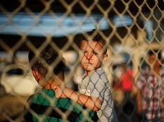 Un niño y un joven esperan a sus familiares en la frontera entre la Franja y Egipto, abierta durante dos días por cuestiones humanitarias.