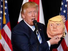 Trump bromeó con una máscara de sí mismo, este lunes en Sarasota.
