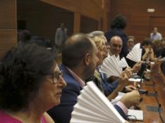 Los diputados de PSOE y Podemos usan abanicos de papel en la Asamblea de Madrid.