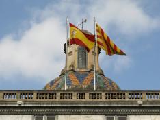 Las banderas española y catalana ondean en la fachada del edificio de la Generalitat en la plaza San Jaume de Barcelona.