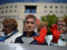 Manifestantes protestan a las puertas de e la Audiencia de Navarra con las manos pintadas de rojo, símbolo contra las agresiones sexistas