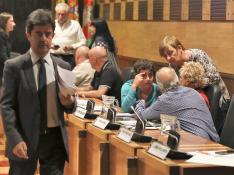 El alcalde de Huesc,a el socialista Luis Felipe, sale del salón de plenos para un receso. A su izquierda, los concejales de Cambiar Huesca hablando.
