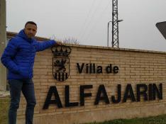El alcalde de Alfajarín, junto a un letrero con la denominación de la localidad.