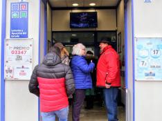 Clientes esperando para comprar lotería ante la puerta de la administración de la avenida Juan XXIII de Huesca.