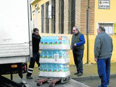 Dos vecinos de El Lugarico de Cerdán, Pepe Marqués y Ricardo Cobo, ayudaron a descargar este jueves las garrafas en las antiguas escuelas