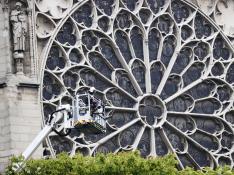 Un bombero trabaja en un elevador junto al rosetón de la catedral de Notre Dame para evaluar los daños.