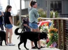 Ciudadanos californianos muestran su respeto ante las flores colocadas por las víctimas del incendio en el barco.