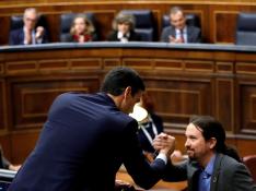Sánchez e Iglesias se estrechan la mano en un momento de la tercera jornada de investidura en el Congreso de los Diputados.