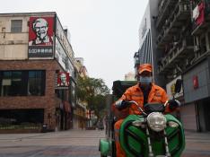 Un trabajador sanitario en su moto este martes por una calle de Wuhan, zona 0 del coronavirus.