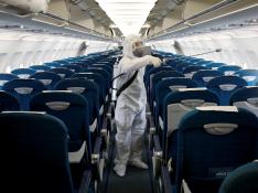 FILE PHOTO: A health worker sprays disinfectant inside a Vietnam Airlines airplane to protect against the recent coronavirus outbreak, at Noi Bai airport in Hanoi, Vietnam