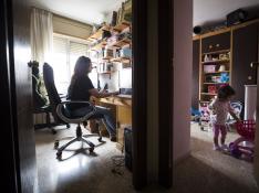 Marian Rivero trabaja como teleoperadora en una habitación mientras su hija de dos años juega en la habitación de al lado.