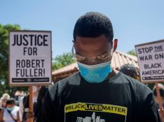 Un manifestante durante el minuto de silencio en una protesta por la muerte de Robert Fuller.