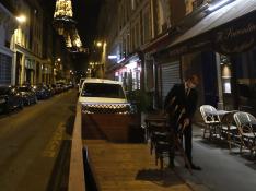 Un camarero retira las mesas de la terraza de un bar en París.
