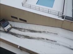 Un coche no puede subir la cuesta del garaje por la nieve.