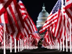 Una persona pasa entre las 200.000 banderas instaladas frente al Capitolio para la investidura de Biden.