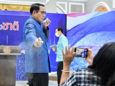 El primer ministro tailandés rocía con gel hidroalcohólico a los periodistas.
